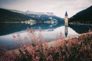 hills and a tower reflecting in lake